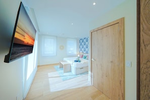 A modern bedroom with a bed, bedside tables, a TV mounted on the wall, and a wooden wardrobe. - Bonsai Accessible 1BR Suite-Forest 111 (Noord)