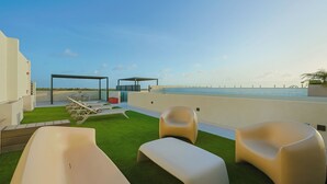 A rooftop terrace with a pool, lounge chairs, and a covered seating area. - Bonsai Studio-Bliss 304 (Noord)