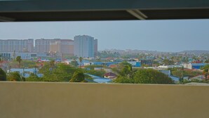A cityscape with residential buildings, some greenery, and a clear sky. - Bonsai Studio-Bliss 304 (Noord)