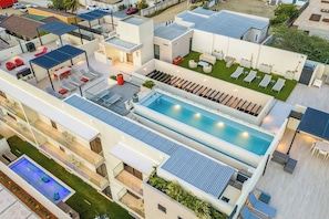 Ett modernt hotell med en pool på taket, flera sällskapsrum och en välskött trädgård.