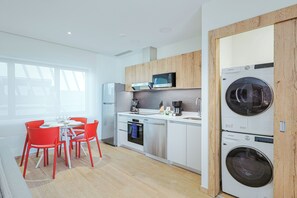 Eine moderne Küche mit Essbereich, ausgestattet mit Edelstahlgeräten, Holzelementen und einem hellen Interieur.
