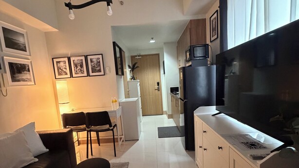 Una sala moderna con un sofá, una mesa de comedor y un televisor.