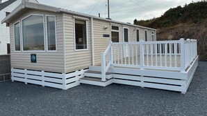 A mobile home with a white deck and a ramp leading to the entrance. - Bwlchgwyn Caravan, Aberdaron (Pwllheli)