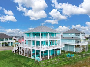 A multi-story waterfront property with balconies, a covered patio, and a grassy lawn. - Gabriel's Landing - Beachfront 5 bedroom - incredible views, sleeps 18 (Crystal Beach)