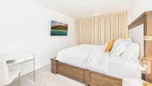 Ein Schlafzimmer mit einem Bett, einem Nachttisch, einer Lampe und einem Bild an der Wand.