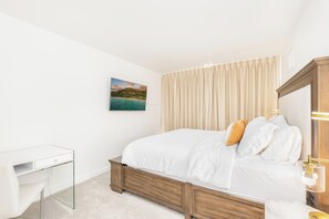 Ein Schlafzimmer mit einem Bett, einem Nachttisch, einer Lampe und einem Bild an der Wand.