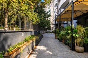 A narrow urban pathway flanked by buildings and potted plants. - Nilvan Apartment heart of Tirana (Tiranë)
