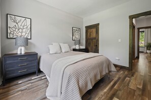 Ein Schlafzimmer mit einem Bett, Nachttischen, einem Kleiderschrank und Bildern an den Wänden.