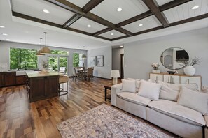 A spacious living area with a large sofa, a dining table, and a kitchen area with a bar. - Luxury Woodland Retreat Near Gull Lake, championship golf & Downtown Nisswa (Nisswa)