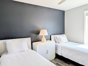A bedroom with two beds, a nightstand with a lamp, and a wardrobe. - 22 South Shore Drive Ext - South Shore Marina (Bethany Beach)