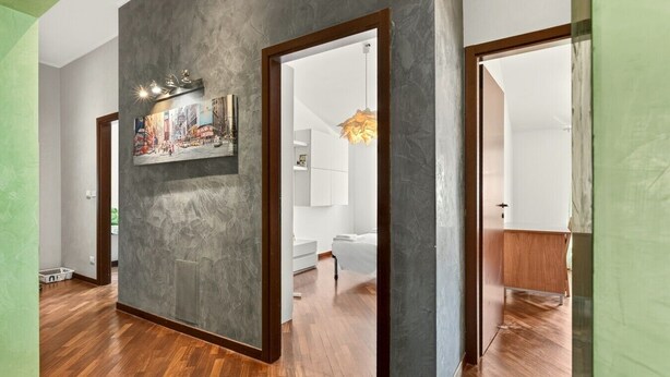 Ein Flur mit strukturierter Wand, Holzboden und einem gerahmten Bild.