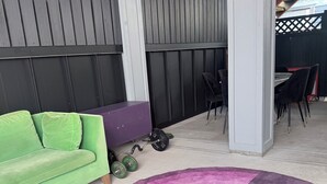 Una habitación con un sofá verde, un mueble morado y un tapete rosa y morado.