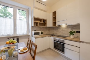 A modern kitchen with white cabinetry, a microwave, an oven, and a sink. - STRAMBIO, 8 – Smart Stay in Milan (Milano)