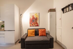 Uma sala de estar moderna com um sofá, um quadro e um armário.