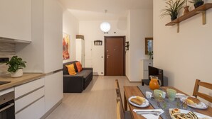 A modern kitchen with a dining area, a sofa, and a table set for breakfast. - STRAMBIO, 8 – Smart Stay in Milan (Milano)