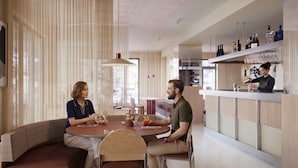 Un interior moderno con una zona de bar, asientos y vistas por la ventana.