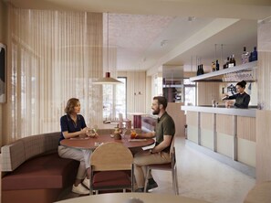 A modern interior with a bar area, seating, and a view through the window.