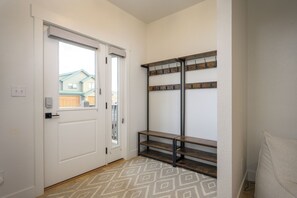 A hallway with a white door, a window, and a wooden bench with hooks. - 1000 Lupine Lane Private home, 4 bedrooms, 2 living areas and VIEWS (Tabernash)