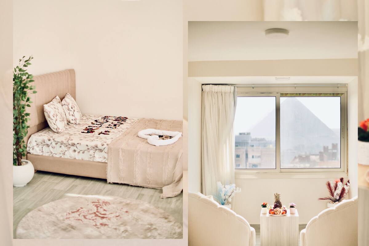 A bedroom with a bed, bedside table, and a window with a view.