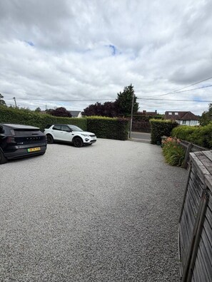 A gravel driveway leading to a white car parked on the side. - Modern Annexe, 10 Minutes from Oxford City Centre (Oxford)