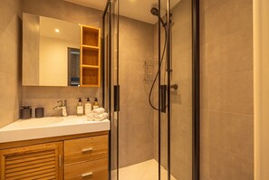 Regadera, secadora de cabello, toallas, papel de baño 