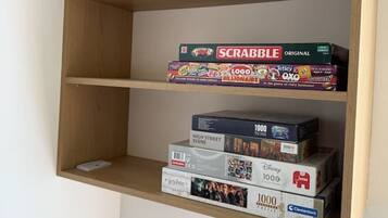 Een plank met verschillende gezelschapsspellen, waaronder Scrabble en Monopoly.