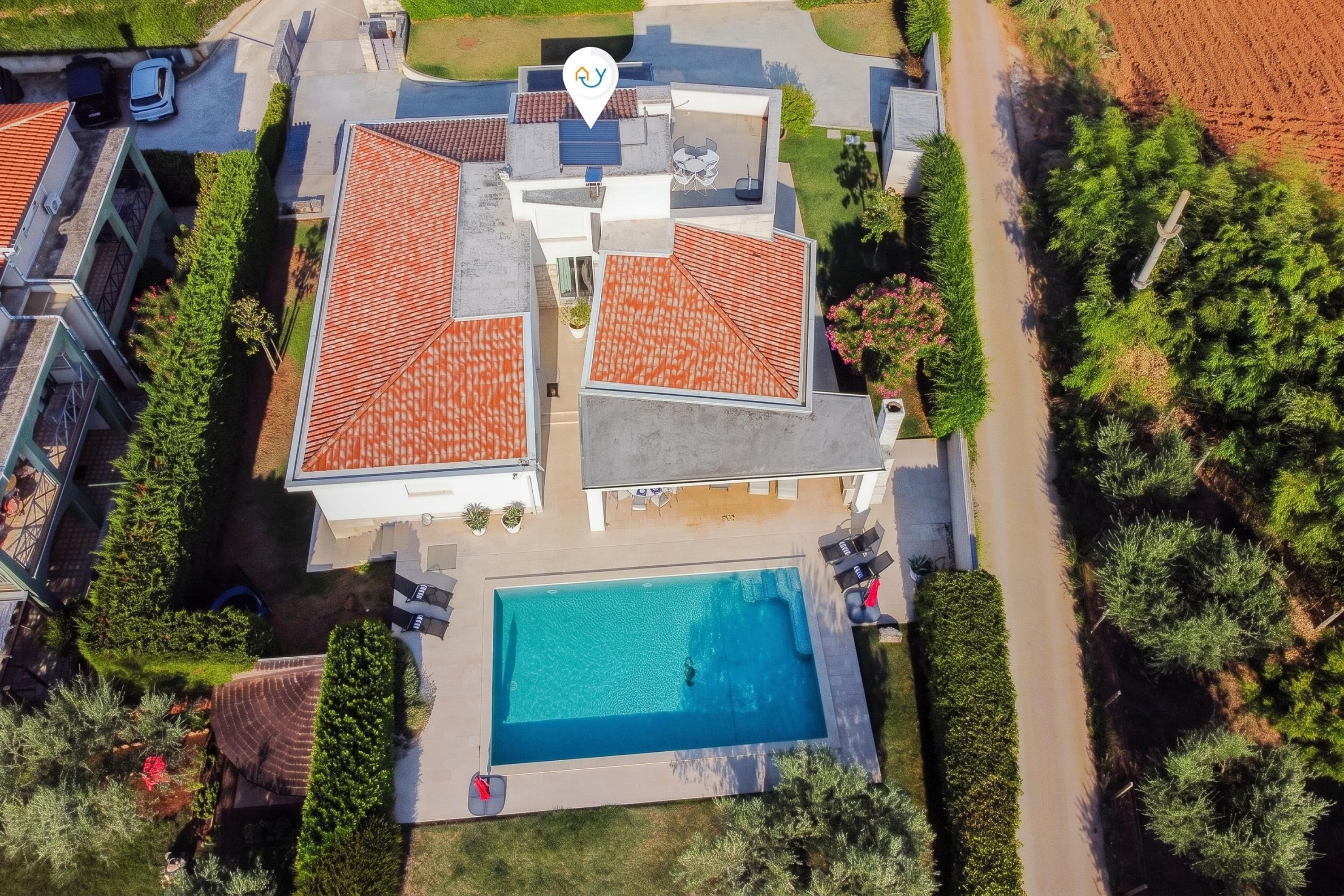 A residential property with a swimming pool, multiple buildings, and a well-maintained garden.