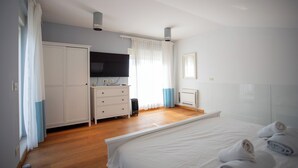A bedroom with a bed, a wardrobe, a television, and a heater. - Villa Lara With Pool Walk To Sea (Medulin)