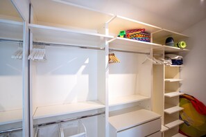 A walk-in closet with open shelves, a hanging rod, and a folded clothes rack. - Villa Lara With Pool Walk To Sea (Medulin)