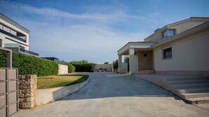 A residential street with modern houses, a paved driveway, and a clear sky. - Villa Lara With Pool Walk To Sea (Medulin)