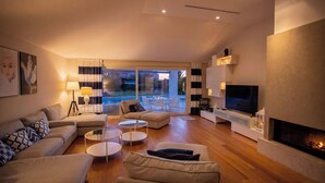 A modern living room with a fireplace, a television, and a pool view. - Villa Lara With Pool Walk To Sea (Medulin)