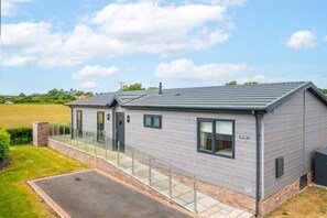Een modern gebouw met twee verdiepingen, een plat dak, grote ramen en een overdekt terras.