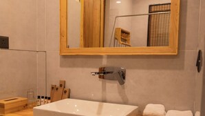 Un bagno con un mobile lavabo in legno, uno specchio grande e un lavandino bianco.