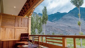Un interno in legno con un balcone affacciato su un paesaggio montuoso.