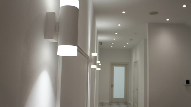 A hallway with recessed ceiling lights and a door at the end.