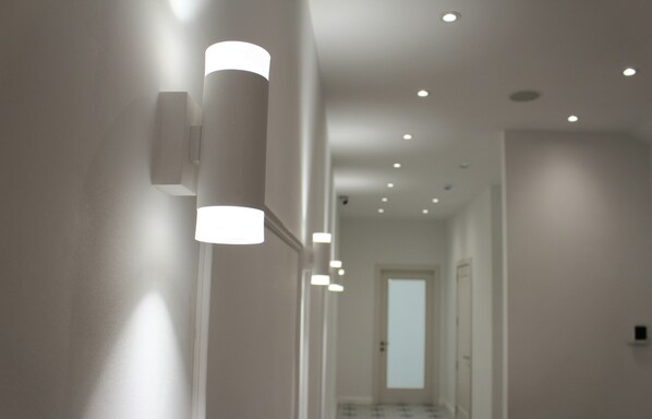 A hallway with recessed ceiling lights and a door at the end.