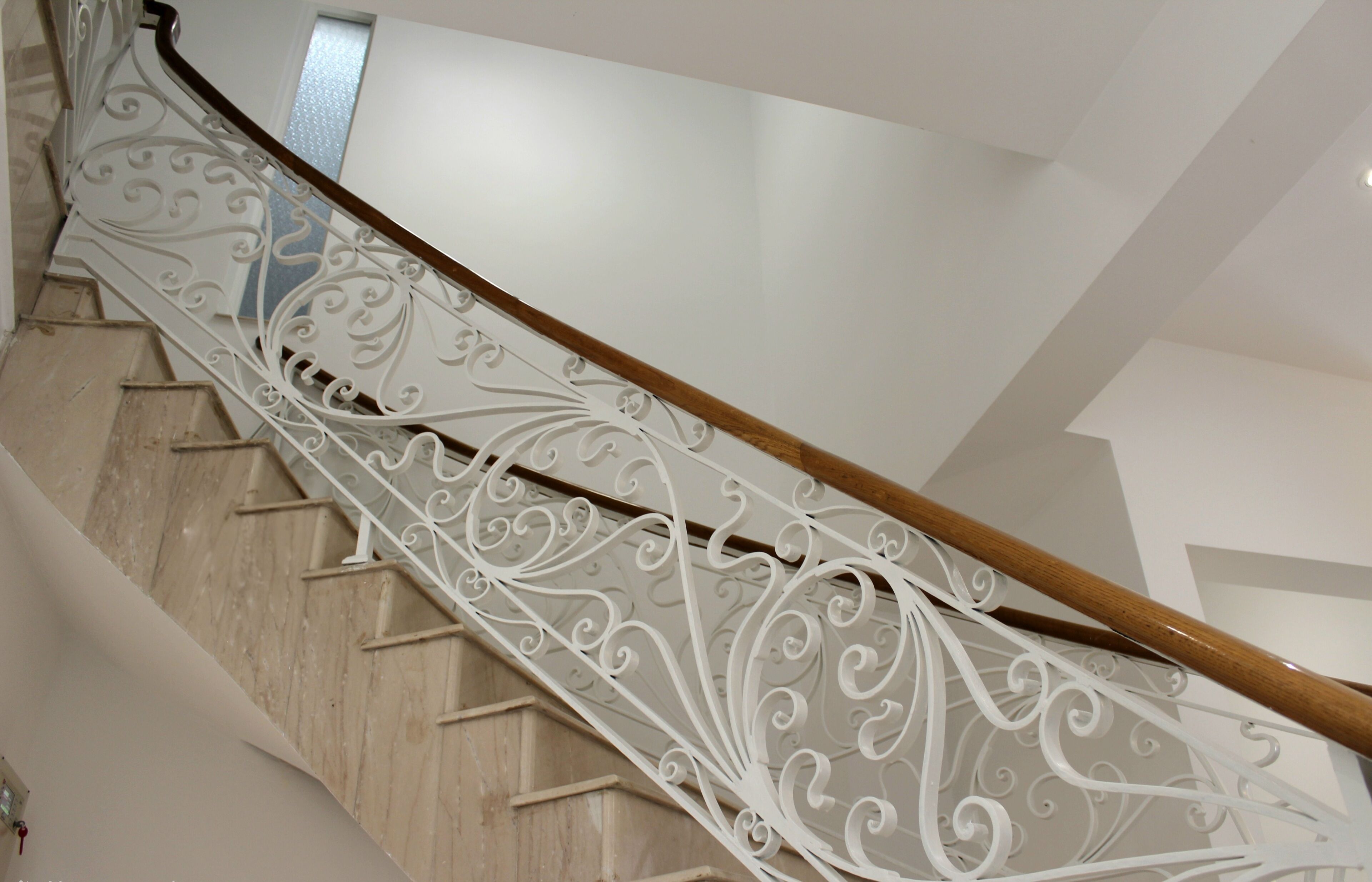A staircase with ornate white railings and wooden handrails.