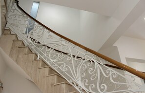 Una escalera con barandales blancos ornamentados y barandillas de madera.