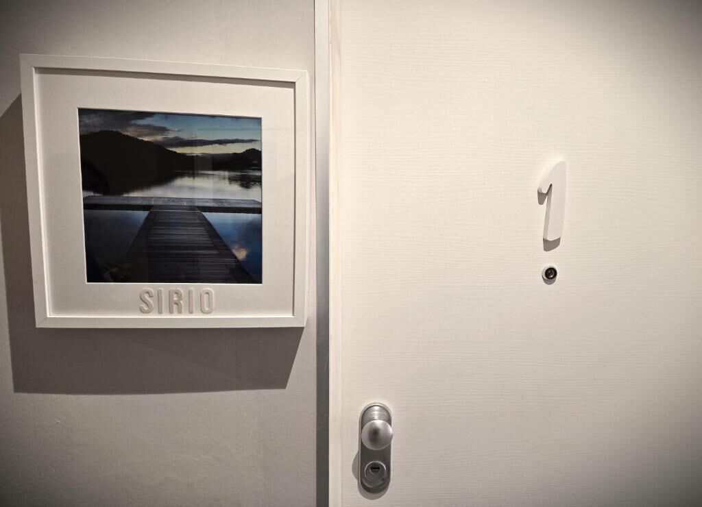A door with a keyhole, a lock, and a framed picture labeled 'SIRIO' on the wall.