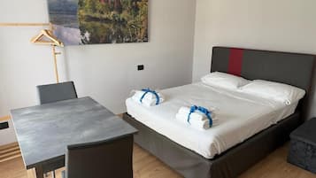 Una habitación de hotel con una cama, una mesa y una silla.