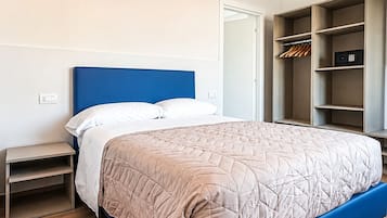 Un dormitorio con cama, mesitas de noche, armario y aire acondicionado.