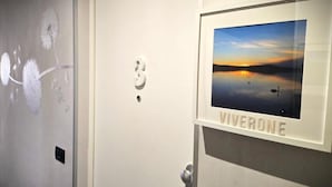 A door with a number '3' and a framed picture of a sunset over water with the word 'VIVERONE' below it. - Seven Lakes ApartHotel RTA (Burolo)