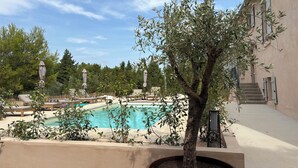 A pool area with lounge chairs and a potted tree. - Pèira House • Swimming pool in the heart of the estate (shared with only one other house) (Bages)