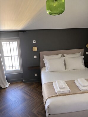 A bedroom with a bed, a window, and a green pendant light. - Pèira House • Swimming pool in the heart of the estate (shared with only one other house) (Bages)