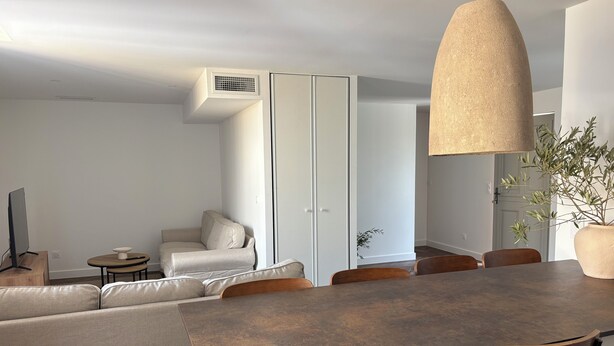 A modern dining area with a large table, chairs, and a hanging light fixture. - Pèira House • Swimming pool in the heart of the estate (shared with only one other house) (Bages)