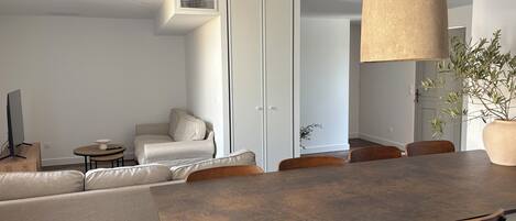 Un comedor moderno con una mesa grande, sillas y una lámpara colgante.