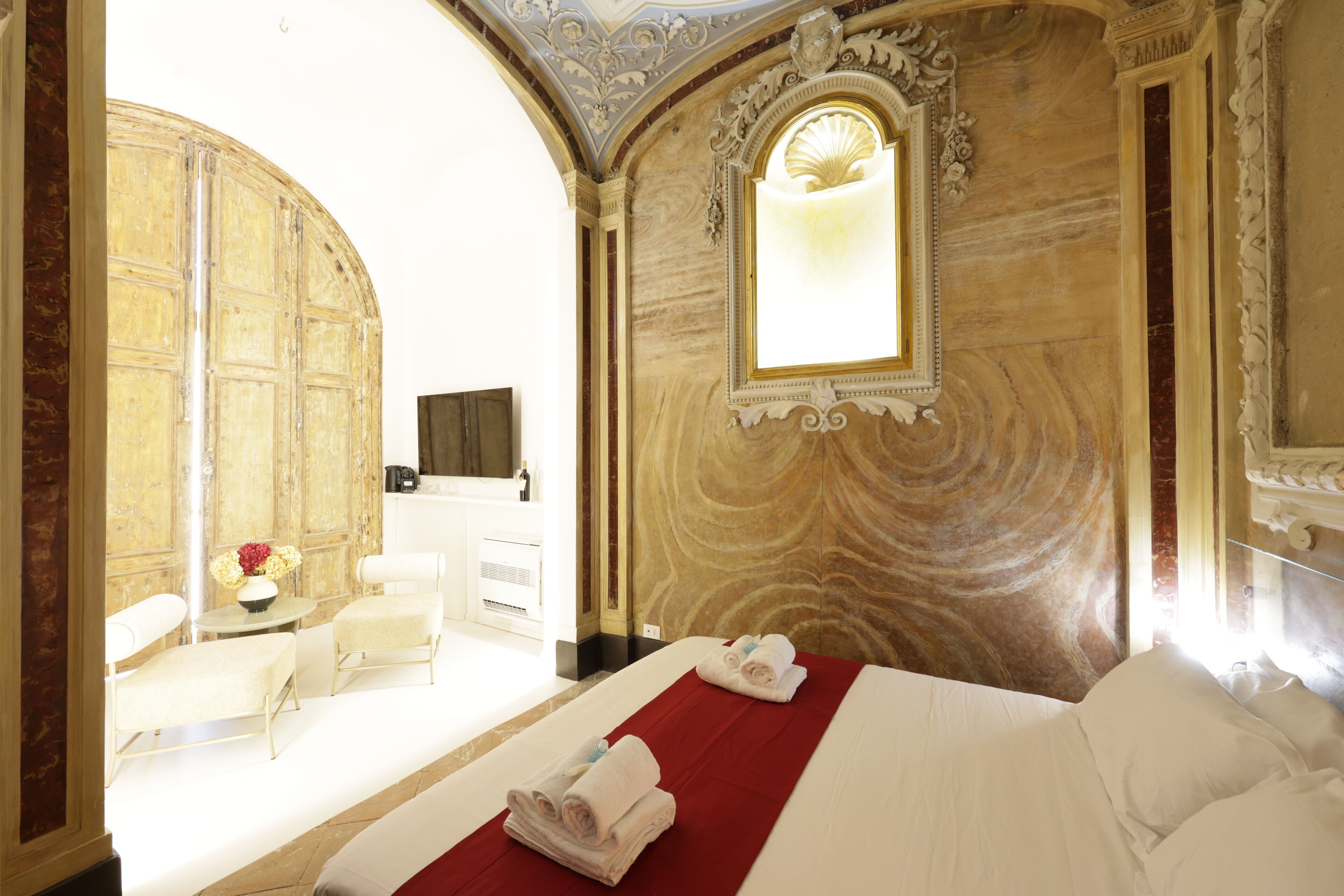 Une chambre d’hôtel avec un lit, un bureau, une chaise et un grand miroir.