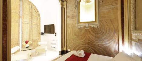 Une chambre d’hôtel avec un lit, un bureau, une chaise et un grand miroir.