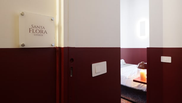 A hotel room with a sign reading 'Santa Flora Superior' on the wall. - Sancta Nolana (Naples)