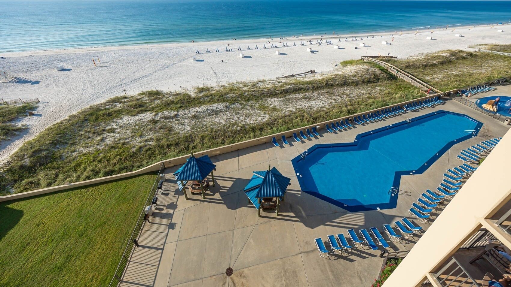 Un complexe hôtelier doté d’une grande piscine, d’un accès à la plage et de chaises longues.